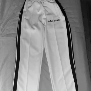 Palm Angels Byxor - Ett par vita Palm angels byxor i bra skick. Ingen märkvärdig defekt förutom något litet smutsigt ställe (skriv privat om du vill ha bättre bild). Storlek S. Köpta här på plick för någon månad sedan. Pris kan diskuteras!