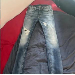 Jack and Jones ”Glenn”  - Jack and Jones i modellen Glenn/Slimfit. Ett äldre par jeans me feta slitningar. Skick 9/10 knappt använda. Storlek 29x34