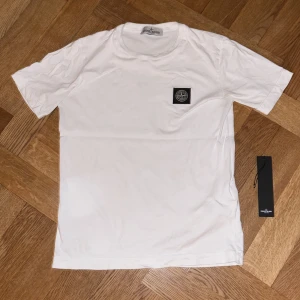 Stone Island T-Shirt - Säljer denna tshirten pga att den e för liten. Den är köpt på NK och nypris är 1100. Storlek 10y passar 12y. Skick 8/10, den har inga synliga fläckar vid användning(bara en liten på badgen i kragen, se bild 5) skicka DM för fler bilder elr frågor!😀