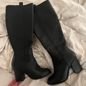 Svarta stövlar med klack - Snygga svarta stövlar i skinn med mellanhög klack och dragkedja på insidan. Perfekta för en stilren look.