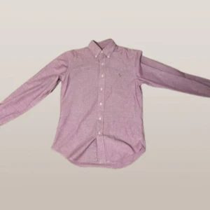 Lila skjorta från Ralph Lauren - Snygg lila skjorta från Ralph Lauren i slim fit. Skjortan har långa ärmar och knappar framtill. Den är broderad med det klassiska Ralph Lauren-logotypen på bröstet. Perfekt för en stilren look. Pris kan diskuteras vid snabb affär💨
