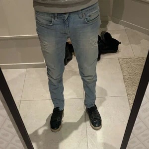 Donup 29/30 - Snygga donup ljusblå jeans med slitningar på framsidan. De har en klassisk femficksdesign och en knappgylf. Perfekta för en avslappnad stil. Fint skick! Strlk 29/30 modellen på bilden är 170cm