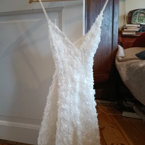 Ida Sjöstedt Charlie dress, vit klänning - Säljer en vacker vit klänning "Charlie dress" från Ida Sjöstedt med blommiga detaljer och smala axelband. Storlek 34.