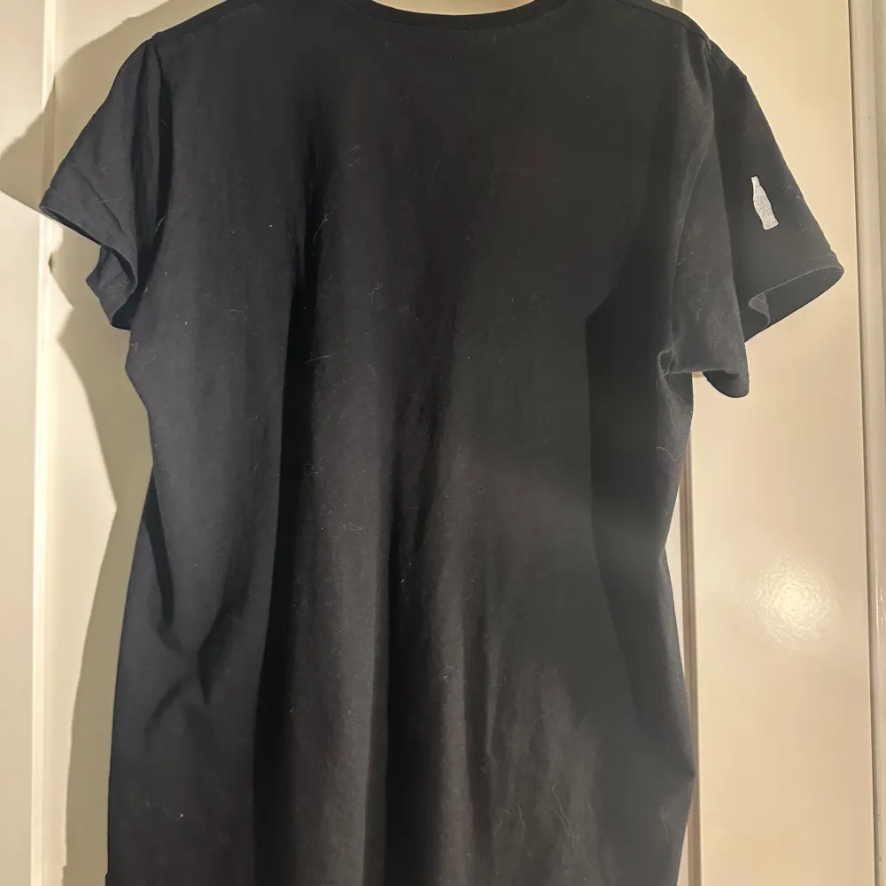 Säljer en svart t-shirt med Coca-Cola-logga i vitt. T-shirten har en klassisk passform och korta ärmar. Perfekt för dig som gillar retrostil och vill ha något bekvämt och stilrent i garderoben.. T-paidat.
