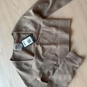Beige croppad topp från Aim'n - Beige croppad topp från Aim'n med långa ärmar och fyrkantig halsringning. Oanvänd med lapp kvar. 