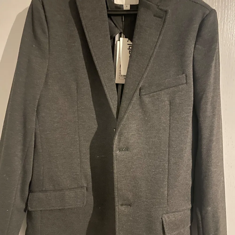 Snygg grå kavaj från Kappahl i storlek S. Kavajen har en klassisk design med knappar framtill och fickor. Perfekt för en stilren look. Aldrig använd pga av för stor för mig. Så i nyskick! Nypris 999. Puvut & Bleiserit.