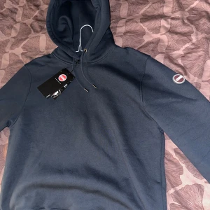 Mörkblå hoodie från Colmar - Säljer en helt ny snygg mörkblå hoodie från Colmar, säljes då den tyvärr inte passade mig