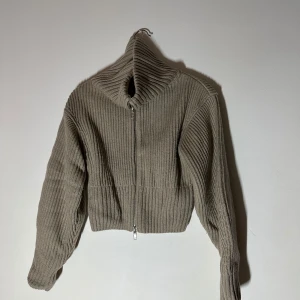 Täcka - Snygg beige kofta med ribbad design och dragkedja framtill. Perfekt för kyligare dagar med sin mysiga och stilrena look. Passar bra till både jeans och kjol🥰🥰🥰