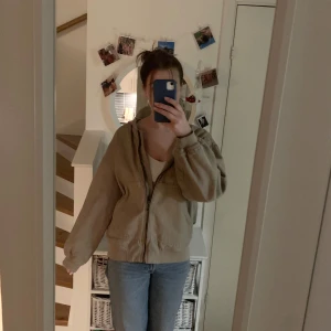Beige bomberjacka - Säljer en beige bomberjacka med dragkedja framtill💕Jackan är i strl M (jag brukar ha S-M, är 175 cm lång) med stor luva och ribbade muddar. Perfekt nu till våren!💕