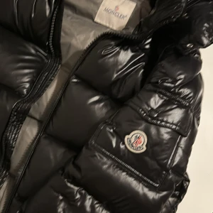 Svart pufferjacka från Moncler . Moncler maya - Säljer en snygg svart pufferjacka från Moncler.