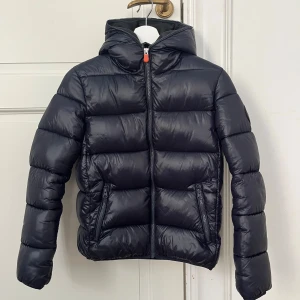 Midnattsblå Vinterjacka från Save the Duck - Midnattsblå snygg vinterjacka från Save the Duck i stl 12 år. Det motsvarar stl 152. Jackan är i mycket bra skick, har använts sparsamt.  Nypris ca 2800kr