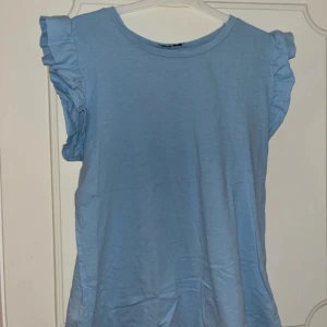 T-shirt  - Fin T-shirt med volang detaljer, aldrig använd☺️vet tyvärr inte vad märket heter
