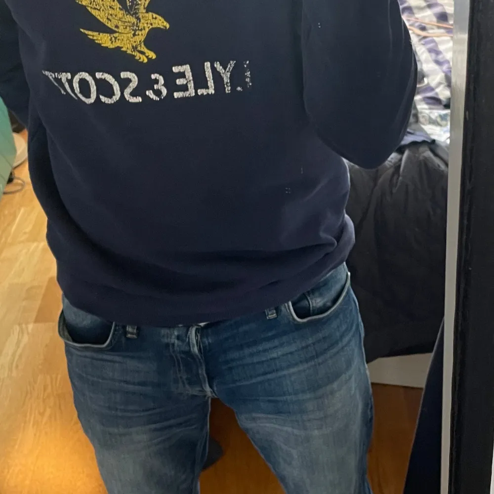 Säljer en snygg mörkblå tröja från Lyle & Scott med deras ikoniska gula örnlogga på bröstet. Tröjan är i storlek L och har långa ärmar. Perfekt för en casual look eller när du vill ha något bekvämt men stilrent. Passar bra till jeans eller chinos!. Tröjor & Koftor.