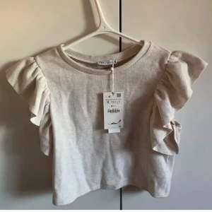Volangtopp zara - Fin beige volangtopp från zara i S 💕skriv för fler bilder!