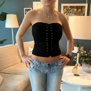 Topp - Skitsnygg bandeau topp med korsett framtill, stretchig och har dragkedja bak så sitter sjukt snyggt! 🩷🩷