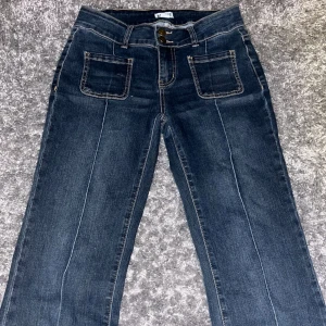 Mörkblå jeans med fickor och knappar - Säljer ett par jättefina lågmidjade mörkblå jeans från madlady. Köptes för 700kr. De har bara använts en gång och är i superbra skick. Säljs då de inte kommer till användning. 💗💘(pris går att diskuteras)