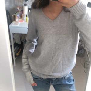 Stickad Tröja - Säljer en supermysig grå stickad tröja från VILA i storlek S. V-ringad. Jätteskön att ha på sig! Säljer en exakt likadan fast i svart, gå in i min profil för att hitta den🤍