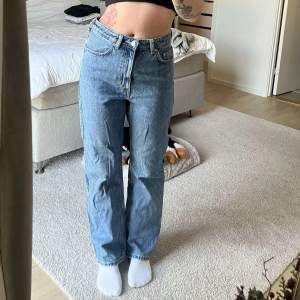 Säljer ett par klassiska blå jeans i bra skick. De har en hög midja och en straight passform som sitter jättebra. Det är från Weekday. Perfekta för både vardag och fest!