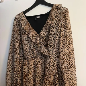 Leopardklänning - En leopardmönstrad omlottklänning köpt på H&M för många år sedan och använd ett fåtal gånger.