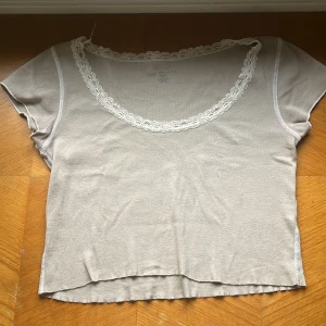 Beige croppad topp med spetsdetaljer - Säljer en brandy topp i bra skick