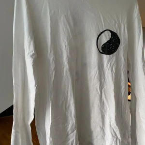 Our Legacy långärmad T-shirt  - Säljer denna snygga långärmade t-shirt från Our Legacy Work Shop. Den har ett fint motiv på ryggen med den klassiska loggan på framsidan. Den är använd fåtal gånger och är i bra skick. Den sitter som en medium.