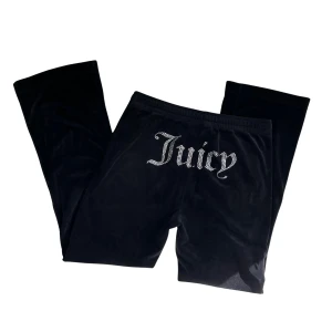 Svarta mjukisbyxor från Juicy Couture - Säljer ett par svarta mjukisbyxor från Juicy Couture i storlek L (men passar även M pga små i storlek). Byxorna är gjorda av mjuk sammet och har en hög midja med snörning. På baksidan finns texten 'Juicy' i glittriga stenar. 