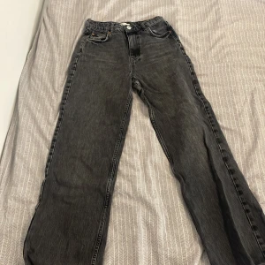 Högmidjade jeans, wide - Ett par mörkgråa jeans ifrån Gina Tricot väl använda Jeansen är högmidjade och vida nedtill Storlek 36  