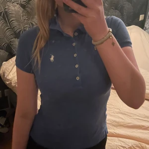 Blå pikétröja från Ralph Lauren - En blå polo Ralph lauren piké med den ikoniska loggan broderat på bröstet🌸 tröjan är använd men i gott skick och inga synliga skavanker💕! priset går att diskutera !