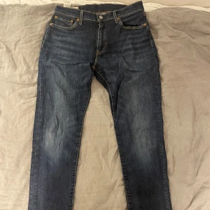 Levis 512 jeans - Snygga Levis 512 jeans i en klassisk blå färg. De har en rak passform med dragkedja och knappar. Schysst blå tvätt med lite fadening på fram p baksida. 