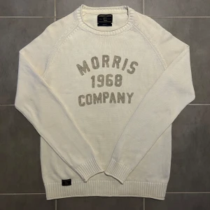 Morris Stickad Tröja Vit M - (Nyskick)Säljer en stilren vit tröja från Morris Gents med texten 'Morris 1968 Company' på framsidan. Tröjan har långa ärmar och ribbade muddar vid ärmslut och nederkant. Perfekt för en avslappnad och snygg look.