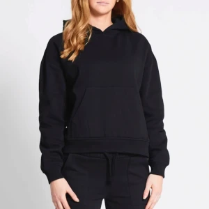 Svart hoodie använd 2 gånger - Säljer en klassisk svart hoodie med luva och känguruficka framtill. Perfekt för en avslappnad stil. Den har långa ärmar och en bekväm passform.
