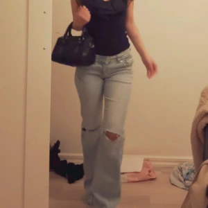 Ljusa jeans med slitningar - Snygga ljusa jeans med slitningar på knäna. De har en straight passform och är lågmidjade, vilket ger en avslappnad look. Perfekta för en trendig stil.