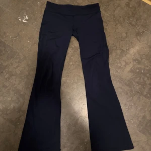 Marinblåa bootcut byxor från Lululemon - Snygga marinblåa bootcut byxor från Lululemon. Perfekta för både träning och vardag med en bekväm passform. Byxorna har en hög midja och är tillverkade i ett stretchigt material för optimal rörelsefrihet.