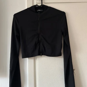 Svart croppad jacka från FB Sister - Snygg svart croppad jacka från FB Sister med dragkedja framtill. Perfekt för en stilren look. Jackan har långa ärmar och en tight passform. Allt tvättas innan det skickas iväg!!  Köparen står för frakten finns på andra sälj sidor med så passa på medans den finns kvar