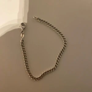 Silver armband - Snyggt silverfärgat armband med klassisk kedjedesign. Perfekt för att ge en stilren touch till din outfit. Armbandet har en praktisk karbinhake för enkel på- och avtagning. Den är bara använd ett få antal gånger och har haft den i två månader, ny pris 700kr