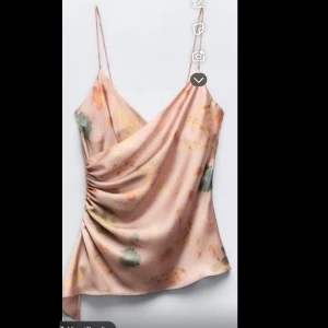 Satin Topp - Säljer ett satinlinne/topp med blommigt mönster i pastellfärger. Toppen går omlott vid bröstet och har detaljer som får toppen att vara figursydd på, den har en asymmetrisk nederkant. Perfekt för en somrig/vårig look! Den är oanvänd och har inga defekter, pris GÅR att diskuter vid SNABB affär!!!💘💘