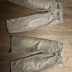 2st baggy jeans  - Två par grå jeansbyxor på köpet. Ena paret har en rak passform medan det andra har en bredare stil. Båda byxorna har klassisk femficksdesign och knappgylf. Perfekta för en avslappnad look. Behöver bort snabbt!!!!!