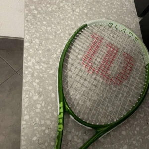 Blade Feel Team 103 Allroundracket (Strängad) - * Allroundracket * Träffyta: 664 Cm² * Vikt: 275 G * Balans: 330 Mm * Strägningsmönster: 16/19 * Délka: 686 Mm lagom för både nybörjare och professionella spelare.