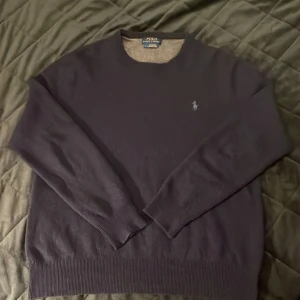 Mörkblå tröja från Polo Ralph Lauren i merinoull  - Säljer en stilren mörkblå tröja från Polo Ralph Lauren.  Tillverkad av italienskt garn. Kan gå ner i pris vid snabb affär. De är lite små håll men de är ihopsydda så märks inte 