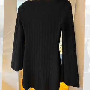 Svart klänning med textur -  svart klänning med långärmad design. Aldrig använd. Prislapp kvar 