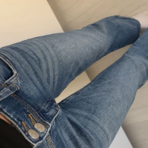 blåa jeans flare - säljer blåa jeans med bootcut-stil och dubbla knappar i midjan. Säljer dessa då dem är för små. Fina fickor och lätt slitna. strl 152 och innerbenslängd 75 cm, kontakta gärna! 