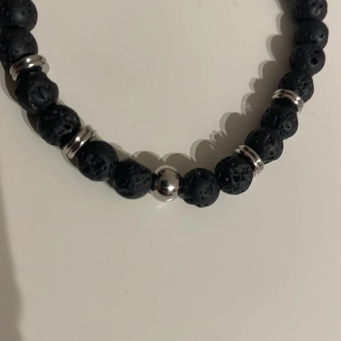 Svart armband med lavastenar och silverdetaljer från edd. - 1