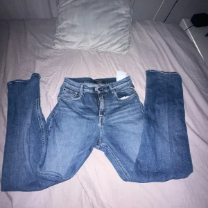 Blå jeans från Replay - Snygga blå jeans från Replay med klassisk femficksdesign och knappgylf. Perfekta för en avslappnad stil. Märkeslogga synlig på fickan.
