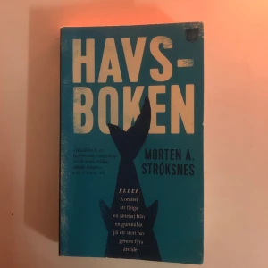 Havsboken - En fascinerande berättelse om konsten att fånga en jättehaj från en gummibåt, skriven av Morten A. Strøksnes. Boken utforskar havets mysterier och äventyr genom fyra årstider.