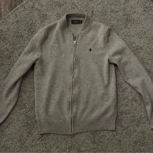 Grå Morris Full zip (Merino ull) - Säljer tröjan eftersom den ej passade när jag fick den. Storleken är från början M men eftersom tröjan blivit tvättad av förra ägaren så är den S/XS. Pris går att förhandla. Tröjan är i riktigt bra skick