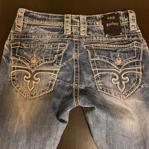 Rock Revival Jeans - Feta Rock Revival Jeans i storlek W32 L34. Byxorna är i bra skick förutom slitningar framtill (bild 3). Skriv vid funderingar eller ifall du vill ha fler bilder. Pris kan diskuteras.