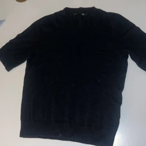 Svart tröja från 157 - Säljer en stilren svart tröja från 157 i storlek XS. Tröjan har korta ärmar och en klassisk design som passar perfekt till vardags. Den är tillverkad i ett mjukt material för extra komfort.