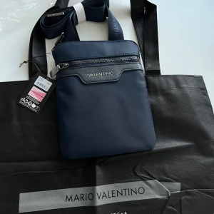Mörkblå axelväska från Valentino - Säljer en hel ny Valentino axelremsväska. Priset online ligger på 979kr mitt pris är 600kr.