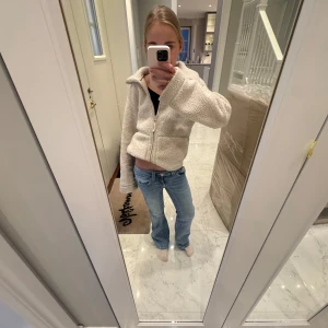 Blå bootcut jeans storlek 146 - Snygga blå bootcut jeans med klassisk femficksdesign och knappgylf. Perfekta för en avslappnad stil med en touch av retro. Passar bra till både sneakers och boots. Storlek 146