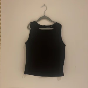 Svart ärmlös topp från XOXO Friends - Säljer en stilren svart ärmlös topp från XOXO Friends. Perfekt för en minimalistisk look. Toppen har en enkel design och är lätt att matcha med olika outfits.